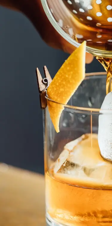 Sazerac bourbon pouring into rocks glass